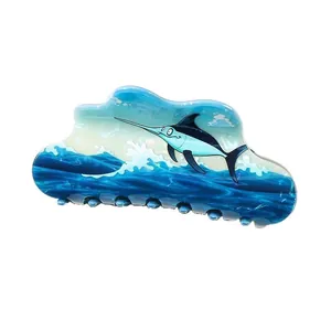 Close-up of wavy ocean hair claw clip with cartoon swordfish and blue wave pattern