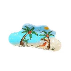 Close-up of cloud-shaped hair claw clip with tropical beach and coconut tree prints