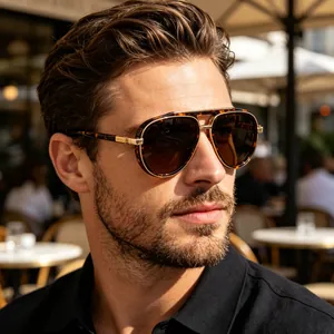 Man wearing classic tortoise and gold pilot sunglasses with brown gradient lenses outdoors