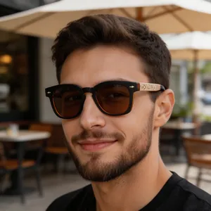 Detail of vintage square sunglasses featuring black frames and gold embossed temple design