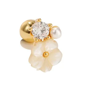 Goldene Blumenohrringe mit Zirkon, Perle und weißem Perlmutt auf weißem Grund