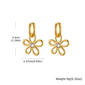 Vue détaillée des boucles d'oreilles fleur dorée avec cristal et fermoir huggie
