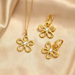 Parure bijoux fleurs évidées dorées avec collier et boucles sur fond en soie