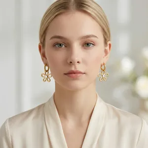 Vue détaillée de boucles d'oreilles fleurs ajourées dorées avec zircon sur modèle