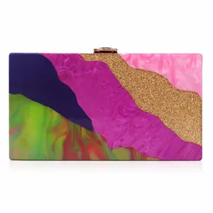 Detailed macro view of wave-patterned acrylic evening clutch with gold metal clasp closure