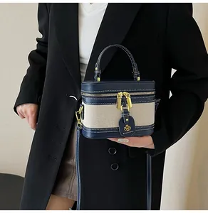 Dettaglio della borsa a scatola bicolore con doppie cerniere dorate e pelle blu