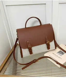 Detail of the brown leather and beige canvas stitching with vintage bronze hardware