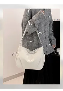 Close-up of white waterproof tote bag with black drawstring details and soft leather texture