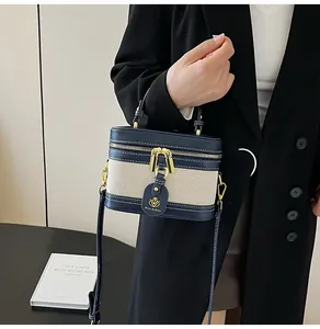 Dettaglio borsa a scatola in pelle blu navy e tela beige con cuciture a contrasto