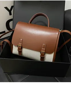 Detail of vintage brown and cream patchwork satchel bag presented in a premium gift box