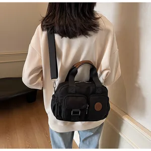 Detail of black multi-pocket canvas crossbody bag with adjustable wide shoulder strap
