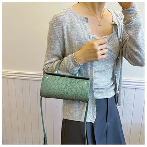 Close-up of bean green vintage box bag with 3D floral embossing and silver hardware