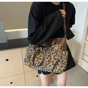 Détail du sac cabas léopard avec anses en cuir marron et bandoulière réglable