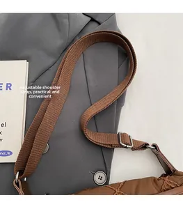 Detail of adjustable brown canvas strap and quilted puffer fabric on a shoulder bag
