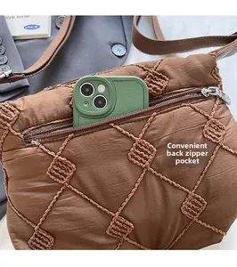 Detail of coffee brown quilted shoulder bag showing functional back zipper pocket for storage
