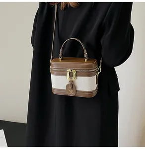 Dettaglio ravvicinato della borsa bauletto retrò con zip dorate e trama in tela
