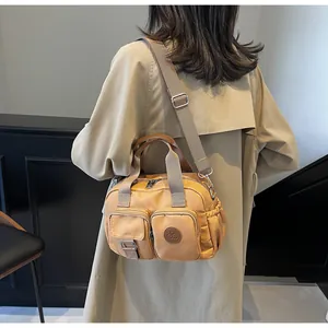 Detailed view of the multi-pocket khaki nylon crossbody bag with adjustable wide strap