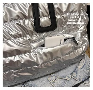 Détail d'un sac argenté matelassé avec poche zippée avant pratique pour batterie
