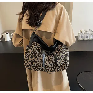 Vue détaillée du sac cabas léopard avec poignées en cuir noir et bandoulière réglable