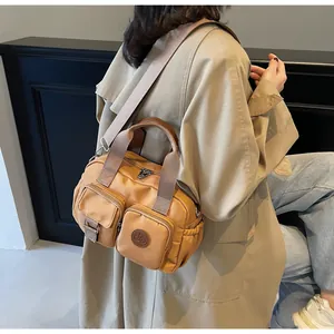 Detail view of mustard yellow canvas crossbody bag with multiple zip pockets and strap