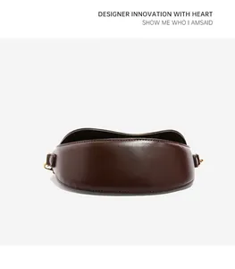 Detailed back view of dark brown crescent saddle bag with smooth leather and gold hardware