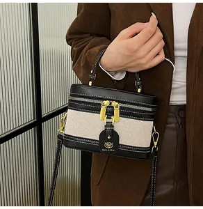 Dettaglio della borsa a scatola patchwork bicolore con finiture dorate e tracolla in pelle