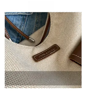 Détail de la texture en toile avec garniture en cuir marron et coutures de précision