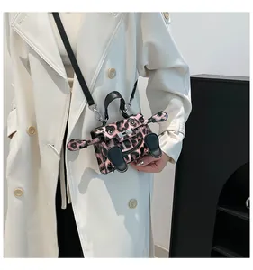 Detail shot of mini pink leopard print Kelly bag with creative cartoon eye design