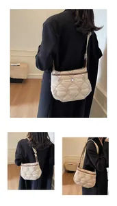 Detail of beige quilted crossbody bag with brown trim and adjustable wide shoulder strap