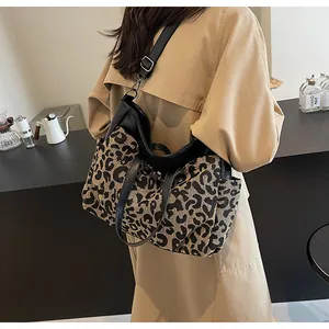 Détail du sac cabas léopard avec poignées en cuir noir et bandoulière réglable