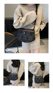 Detail of black quilted puffer bag showing brown leather trim and nylon shoulder strap