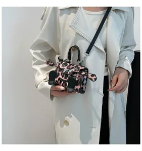 Detail of a mini leopard print handbag with cartoon eyes and black leather ear accents