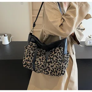 Détail du cabas imprimé léopard avec coutures en cuir noir et bandoulière réglable