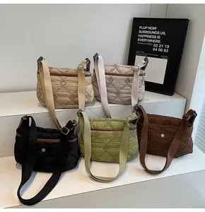 Group shot of five quilted crossbody bags in various colors on a white step display