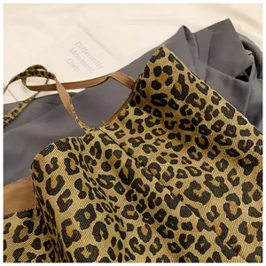 Detail shot of leopard print canvas tote bag with slim brown shoulder straps