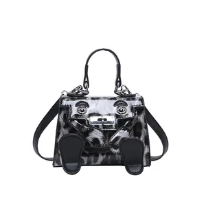 Detail view of the mini Kelly bag featuring a cartoon face design and animal patterns