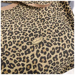 Close-up of leopard print fabric bag showing detailed texture and handmade metal badge