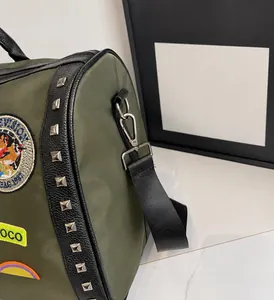 Macro detail of green nylon travel bag featuring metal rivets and embroidered patches