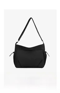Detailed view of the black nylon crossbody bag featuring adjustable straps and side drawstrings