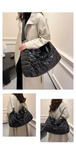 Détail de la texture en nylon matelassé noir et coutures ondulées du grand sac fourre-tout