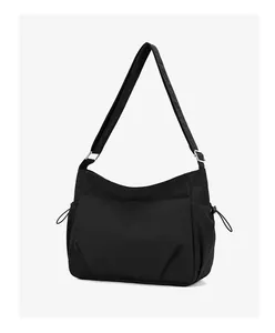 Detail of black nylon messenger bag with adjustable strap and multiple storage pockets
