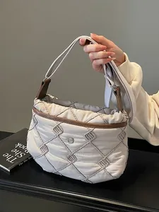 Quilted off-white crossbody bag with brown leather trim and diamond embroidery pattern