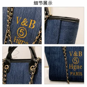 Detailansicht der dunkelblauen Denim-Tasche mit gelber Stickerei und Goldkette