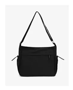 Close-up of black nylon crossbody bag featuring waterproof material and adjustable strap