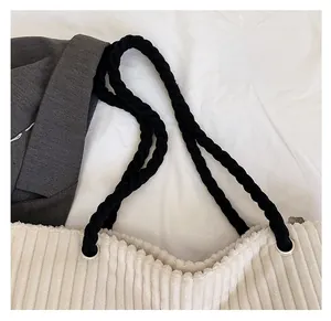 Détail des bretelles en corde tressée et des œillets sur un sac cabas en velours