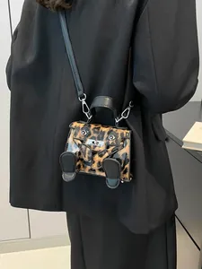 Mini leopard print Kelly style handbag with cute ears and feet worn by a fashion model