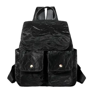 Sac à dos noir élégant pour femme en similicuir brillant avec des boucles dorées chic
