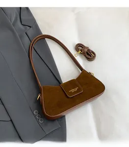 Detail of dark brown crescent bag with matte texture and gold hardware accessories
