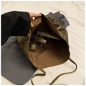 Top view of large leopard print tote bag interior showing spacious capacity with makeup items