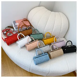 Macro shot of colorful leather cylindrical bags featuring exquisite floral embossing detail